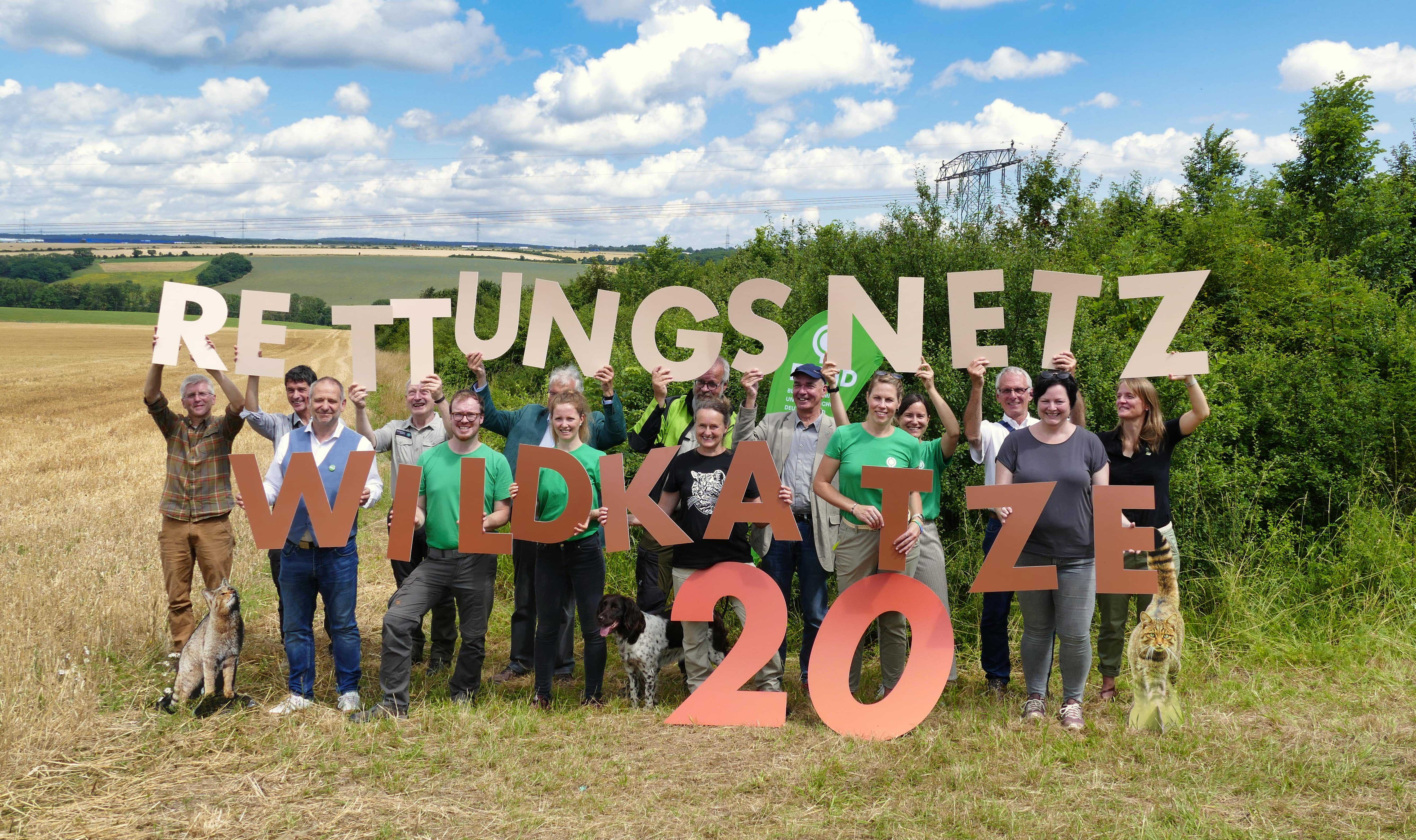 Gruppenbild mit den Buchstaben 20 Jahre Rettungsnetz Wildkatze auf dem Wildkatzenkorridor